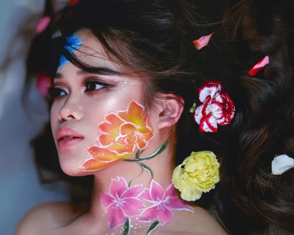 Nainen Studio Lumossa, kasvoihin ja kaulalle maalatut kukkakoristeiset kasvomaalaukset